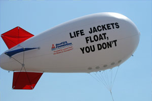View of a blimp which has written on it, Life Jackets Float, You Don't