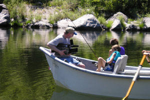 Image of a boat with two kids fishing. They are being video recorded for Redwood Empire Public Television of Eureka, California.