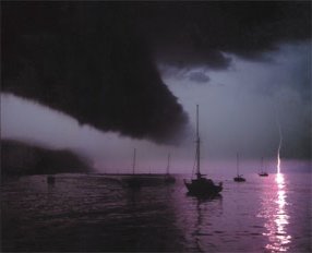 a very dark thunderstorm approaches some moored boats, while lightning is seen in the distance