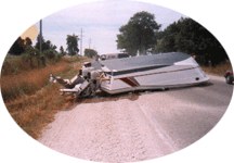 a boat that's fallen off a trailer on a road
