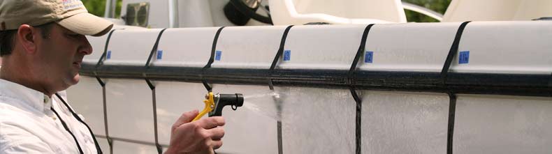 A man sprays clean an area of the boat.