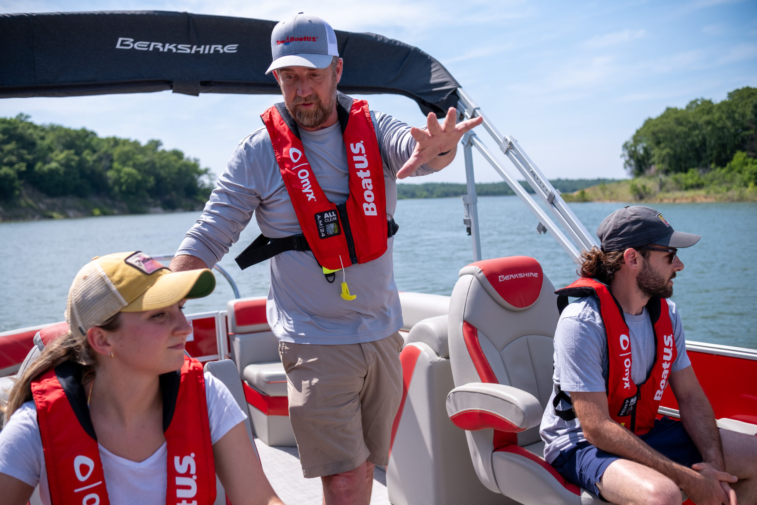 Students in life jackets receive instruction on a motor boat.