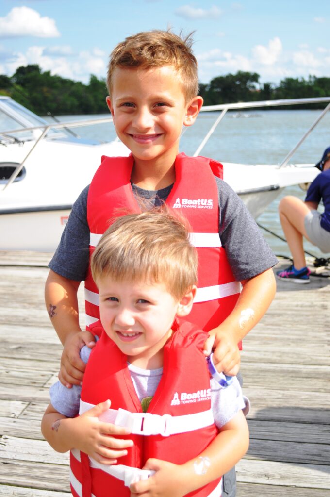Photo of two boys in red life jackets on a dock