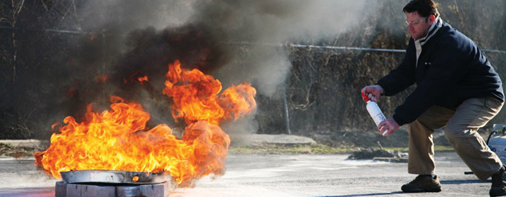 A man uses a fire extinguisher to put out a fire.